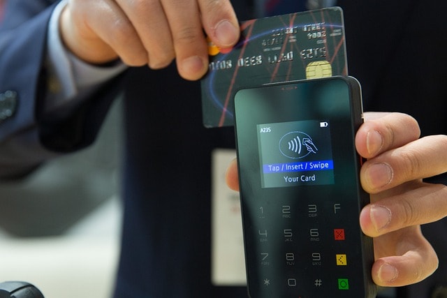 a person holding a credit card and a phone